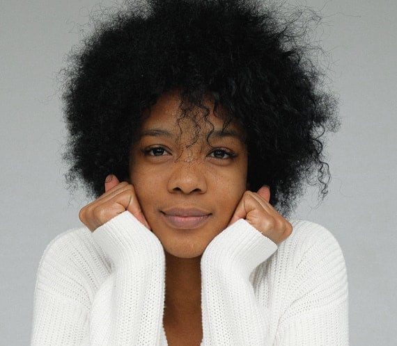 Black women in white sweater and natural hair