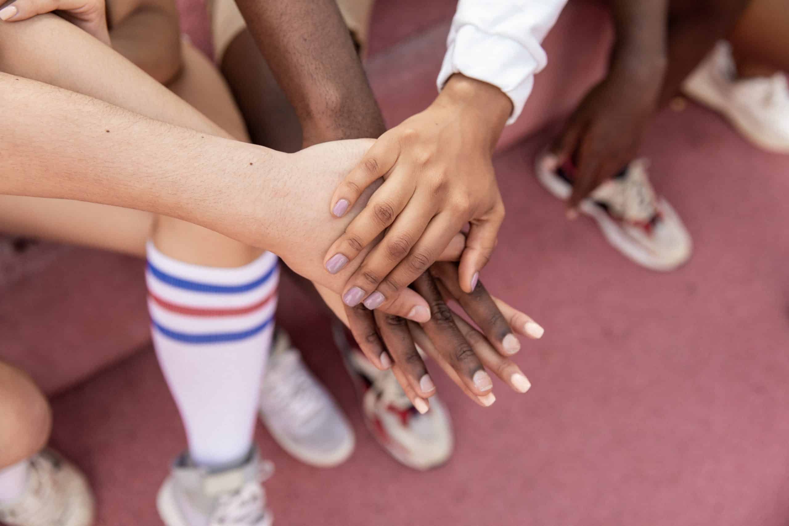 Multiracial team huddle with overhead view of hands and feet only